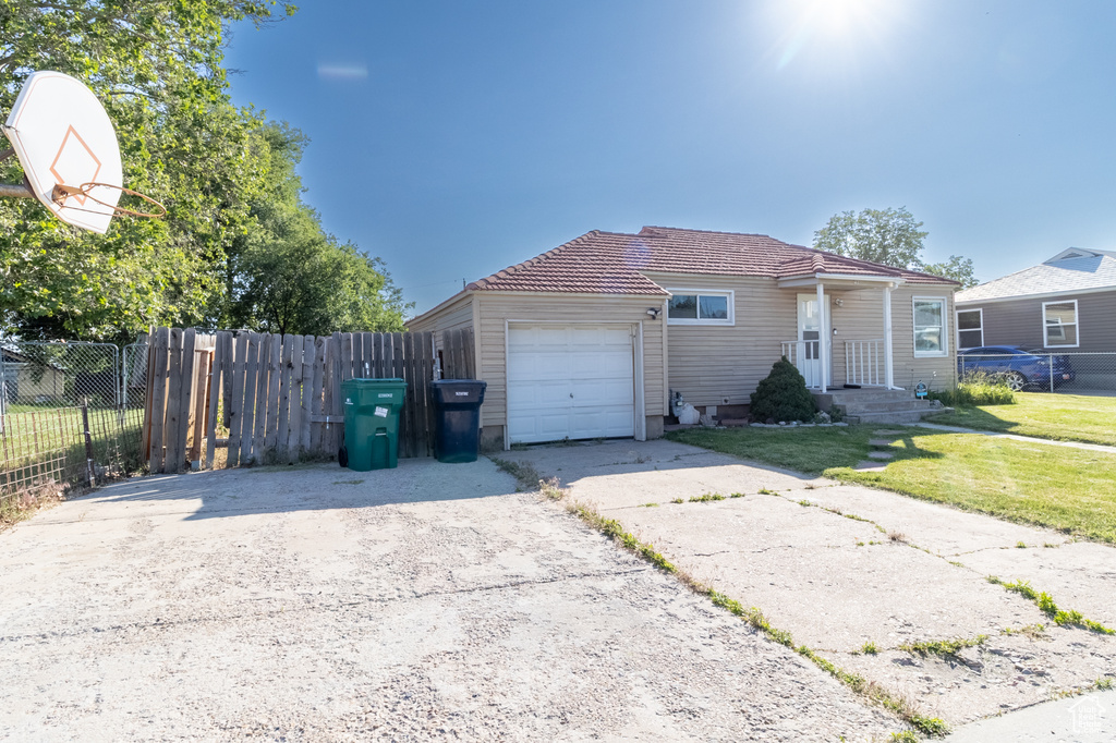 View of front of home with a garage, asphalt driveway, and a tiled roof
