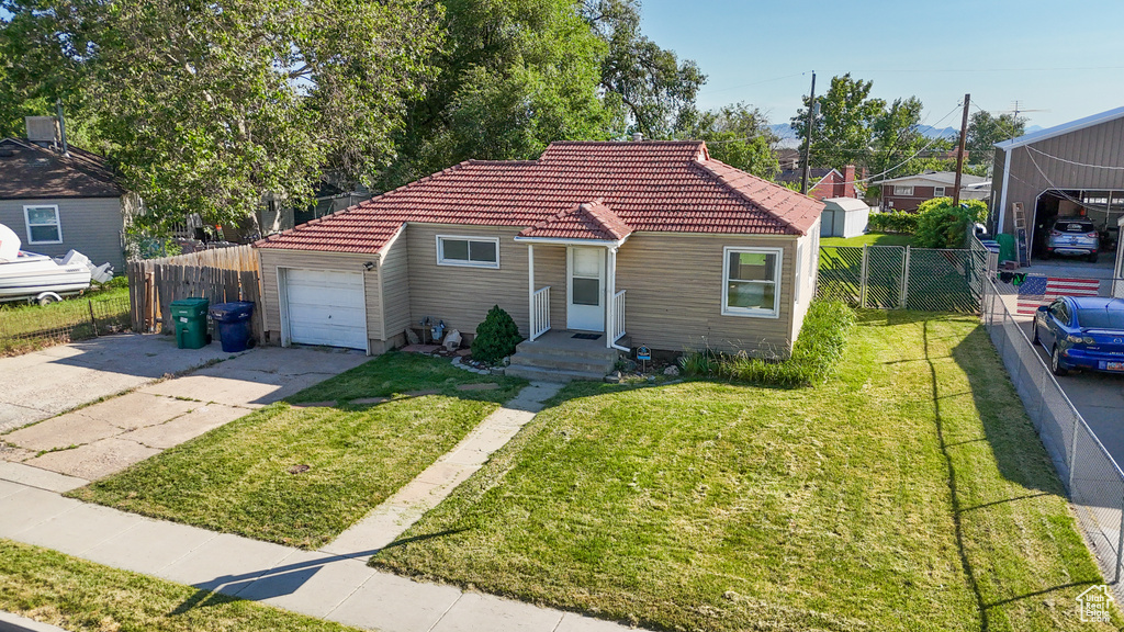 View of front of house featuring a tiled roof, an attached garage, and concrete driveway