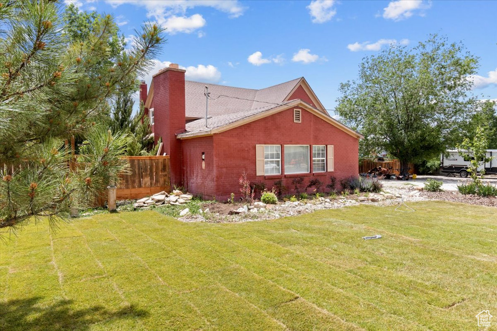 View of side of property with a chimney and brick siding