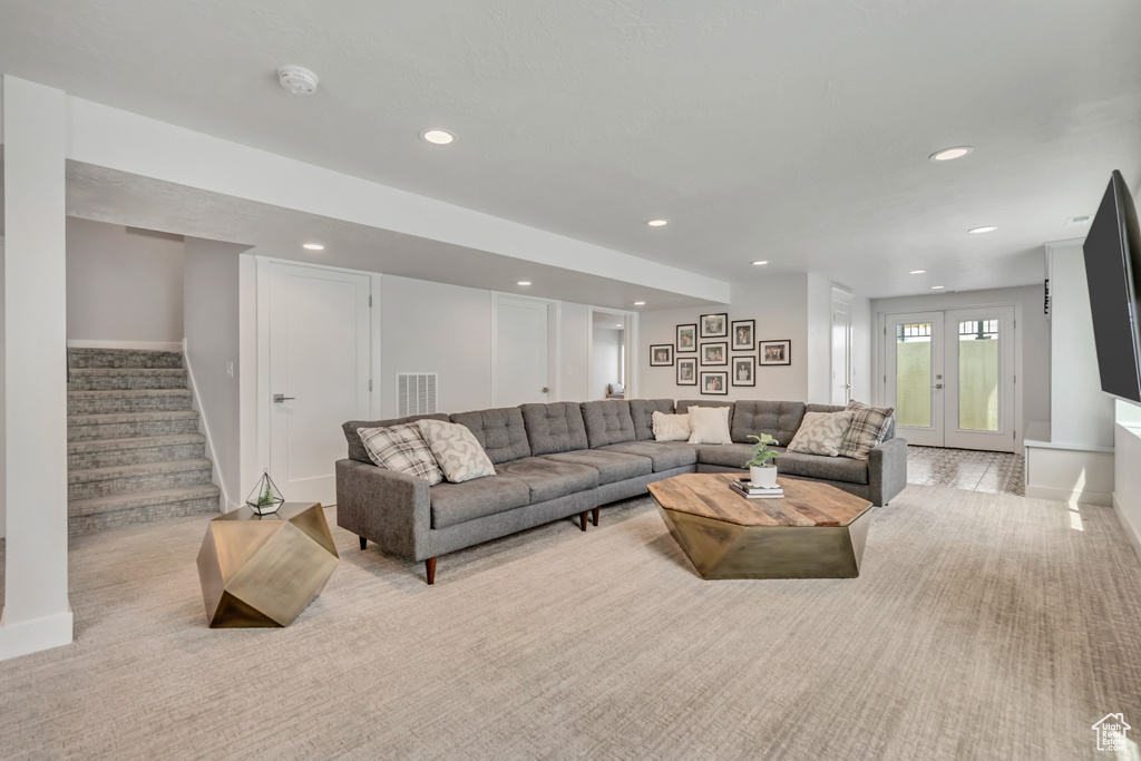 Living room featuring baseboards, recessed lighting, stairway, and light carpet