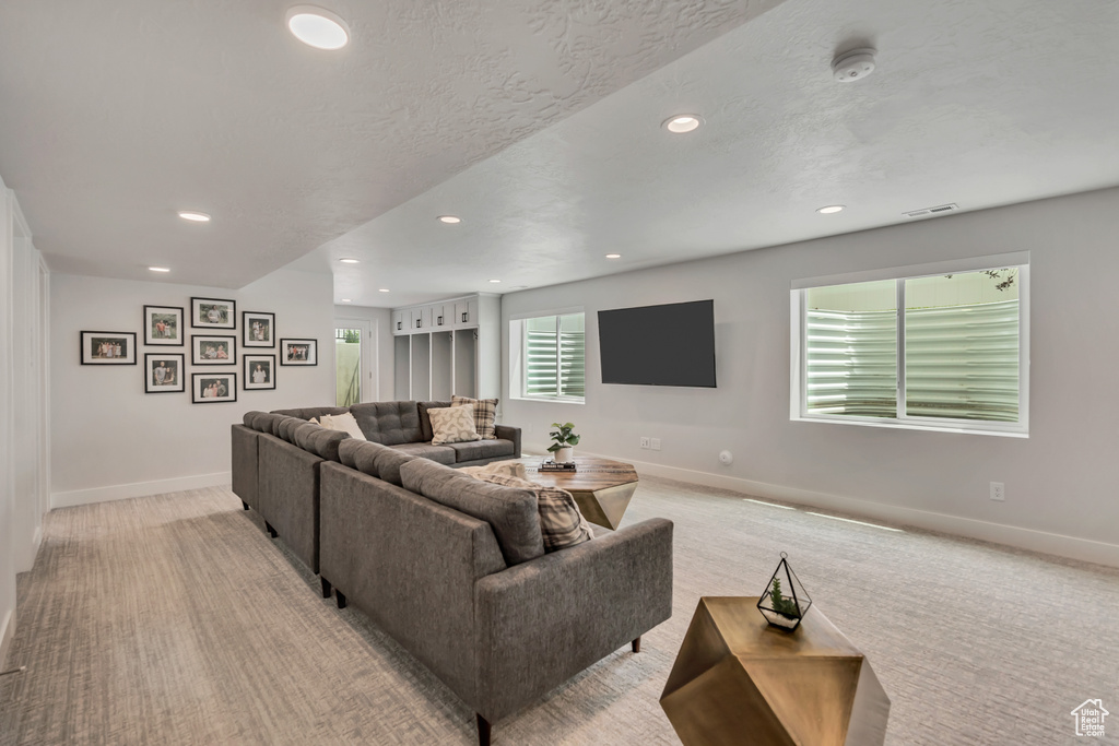 Living area featuring recessed lighting, baseboards, and light colored carpet