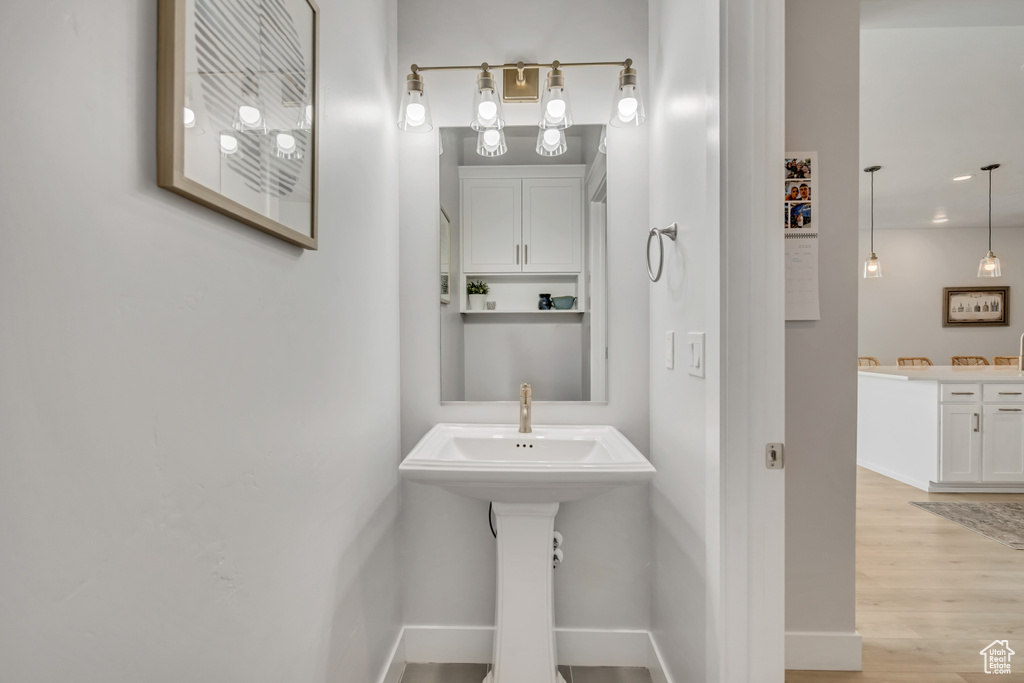 Bathroom featuring wood finished floors, baseboards, and a sink