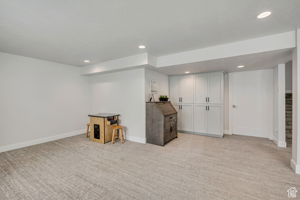 Below grade area with light carpet, recessed lighting, and baseboards