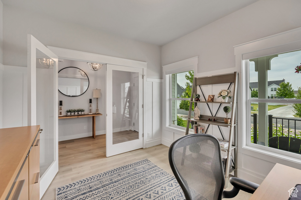 Office area with healthy amount of natural light, light wood-type flooring, a chandelier, and french doors