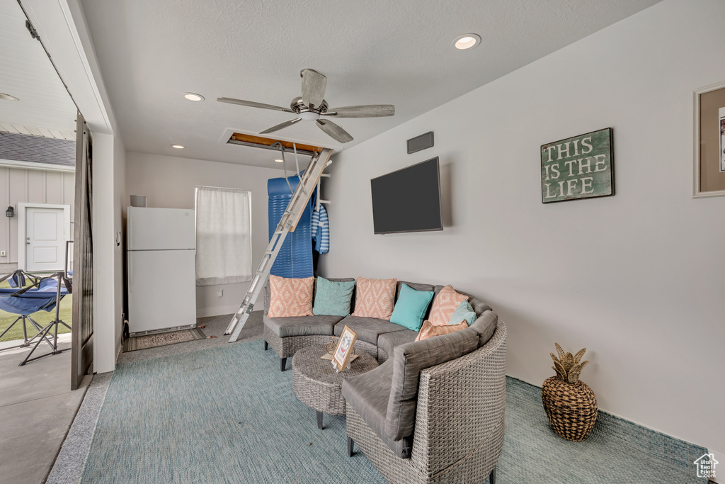 Living area featuring a ceiling fan, recessed lighting, and concrete floors