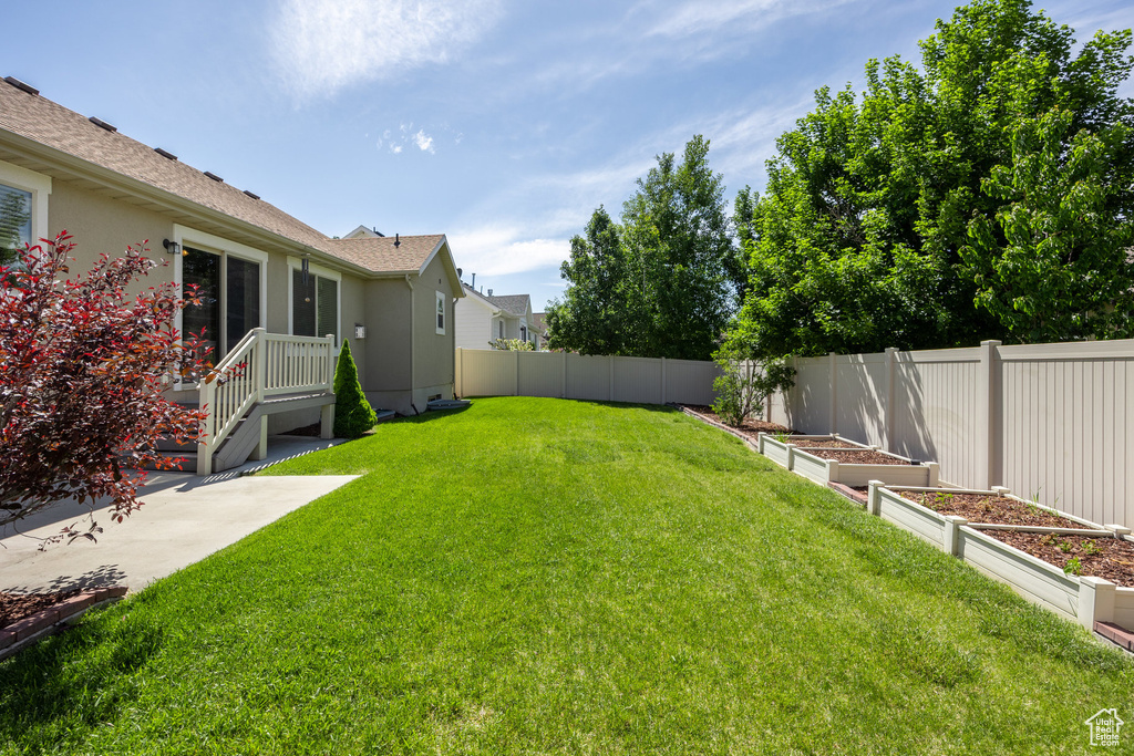 View of yard featuring a vegetable garden and a patio area