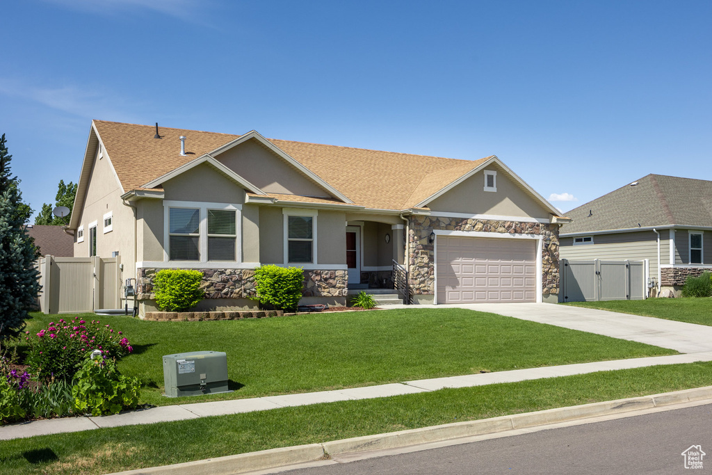 View of front of house featuring a gate, stucco siding, stone siding, a garage, and concrete driveway