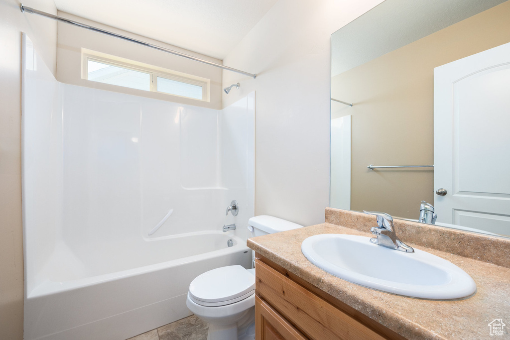 Bathroom with toilet, shower / bathtub combination, and vanity