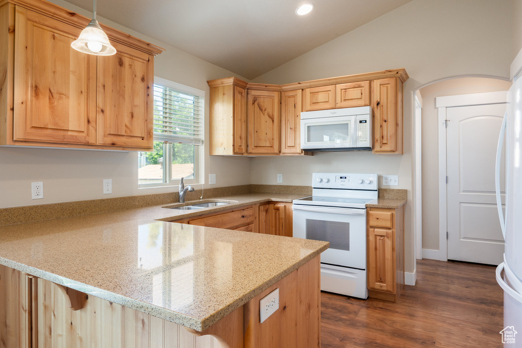 Kitchen featuring white appliances, a sink, a peninsula, lofted ceiling, and light stone countertops