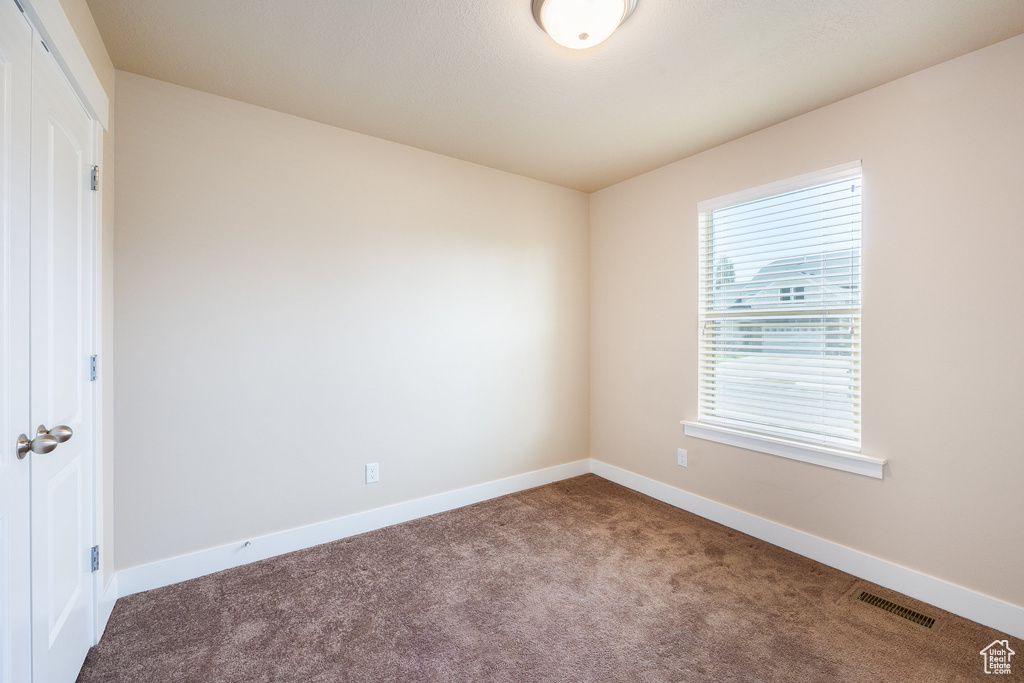 Carpeted spare room with baseboards