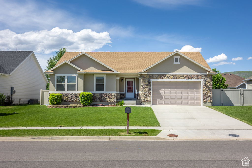 Ranch-style house featuring a gate, stucco siding, stone siding, a garage, and concrete driveway