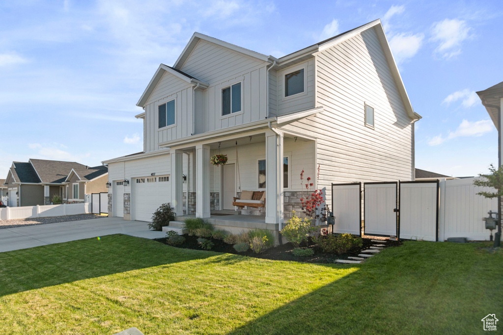 Modern inspired farmhouse with a porch, board and batten siding, a garage, concrete driveway, and a gate