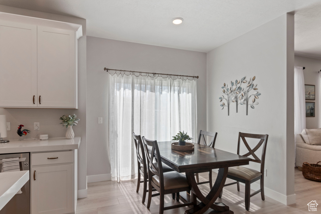 Dining space with baseboards and light wood-type flooring