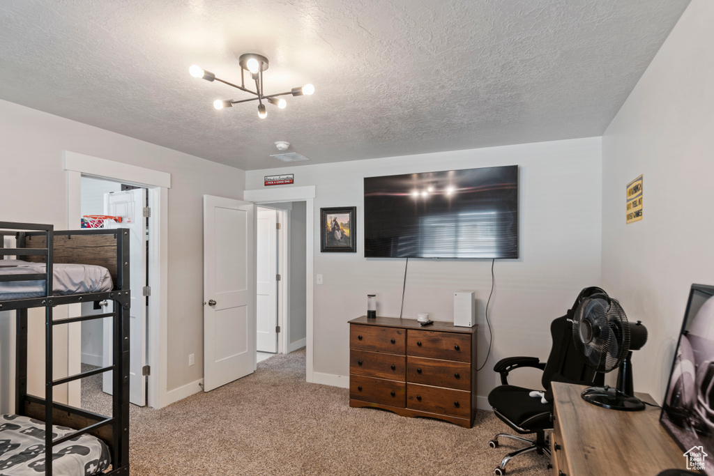 Bedroom with carpet, a chandelier, a textured ceiling, baseboards, and an office area