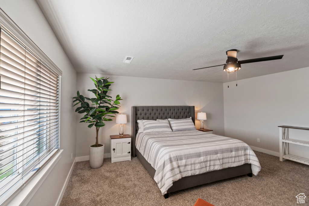 Carpeted bedroom with ceiling fan and baseboards