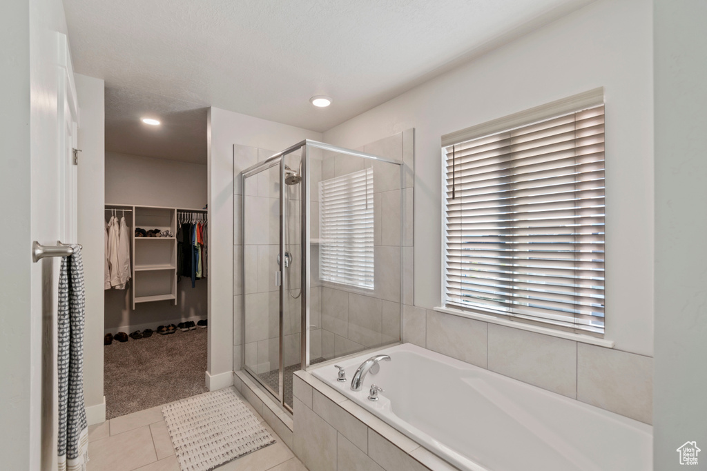 Bathroom with a stall shower, a garden tub, healthy amount of natural light, a spacious closet, and recessed lighting
