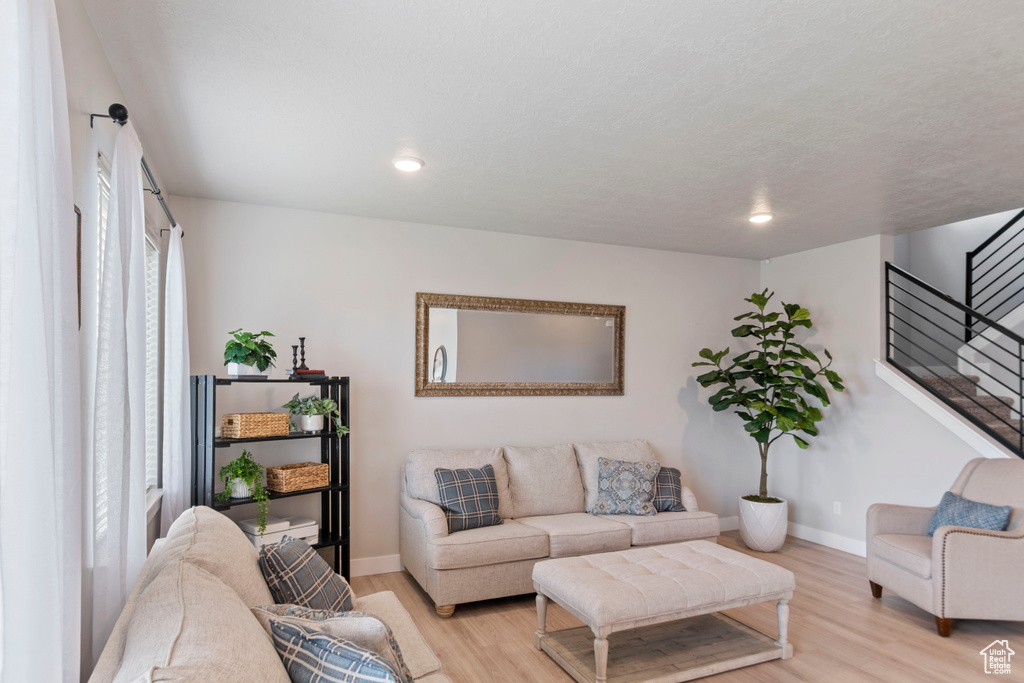 Living area featuring stairs, wood finished floors, baseboards, and recessed lighting