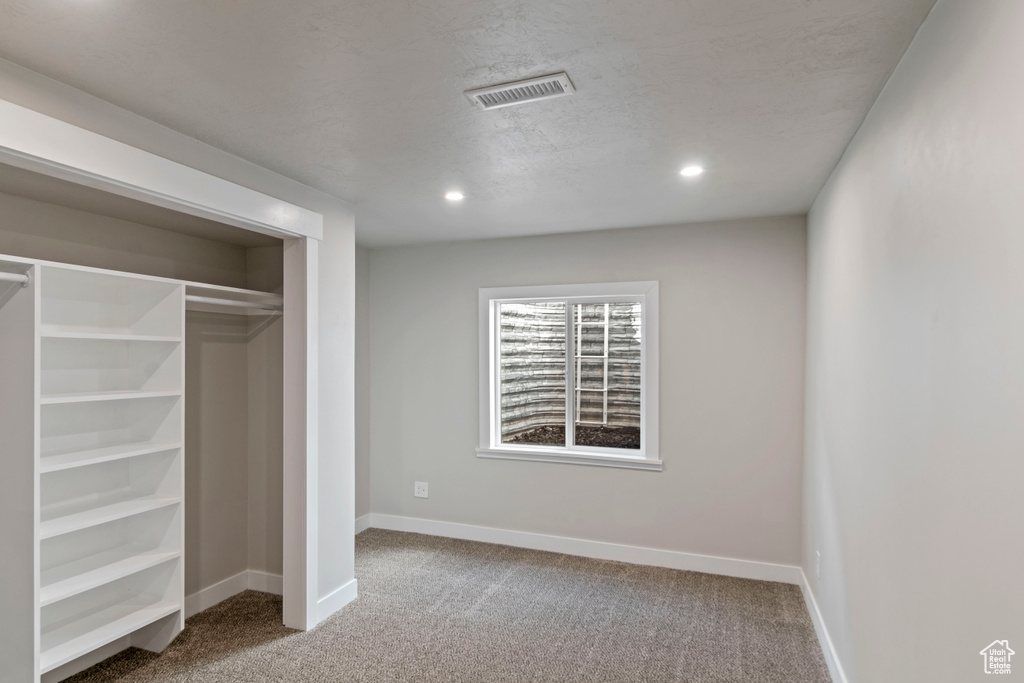 Unfurnished bedroom with carpet, recessed lighting, baseboards, a closet, and a textured ceiling