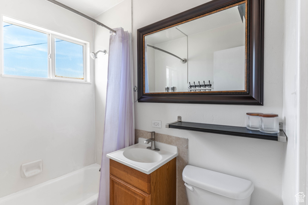 Full bathroom with shower / tub combo, vanity, and toilet