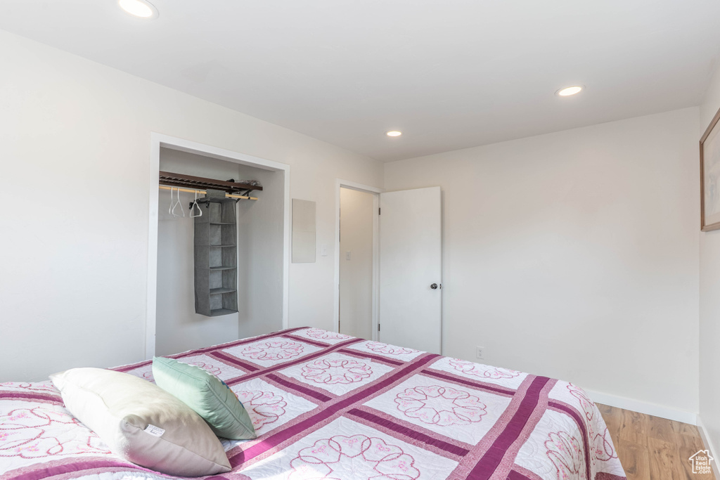 Bedroom with light wood-type flooring, recessed lighting, baseboards, and a closet