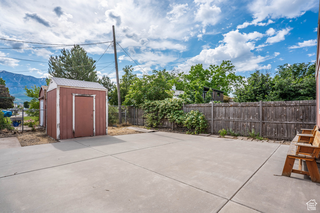Fenced backyard featuring a patio area and a mountain view