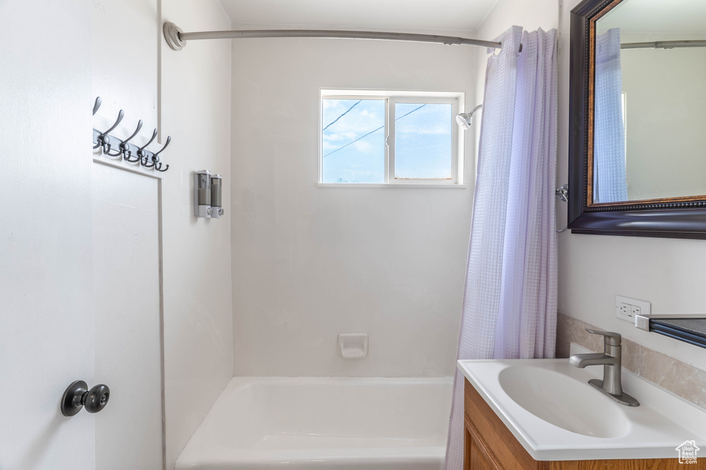 Bathroom featuring shower / bath combination with curtain and vanity
