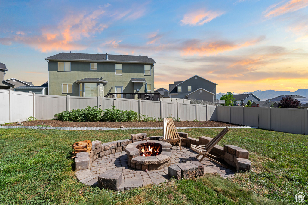 Yard at dusk featuring a fire pit and a patio area