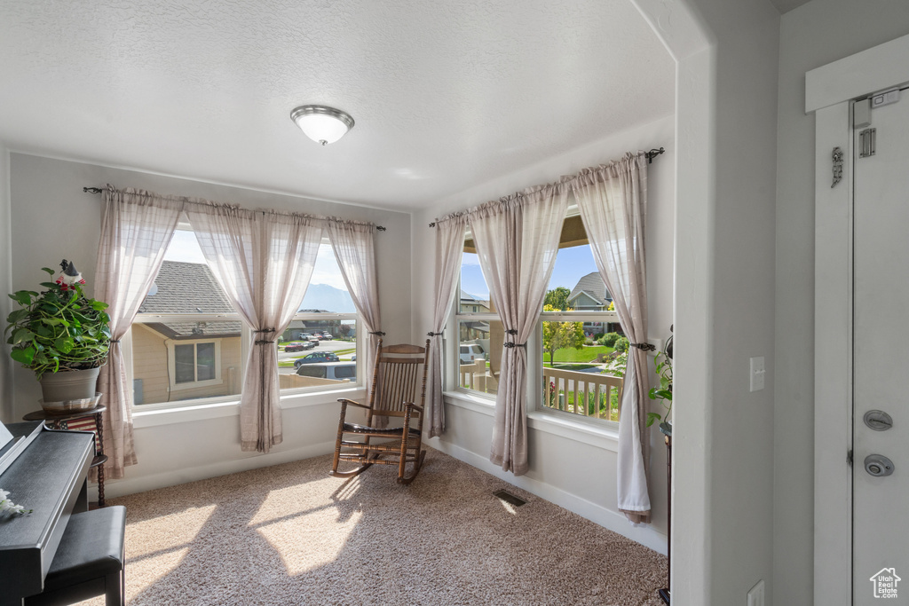Living area featuring carpet floors, arched walkways, and baseboards