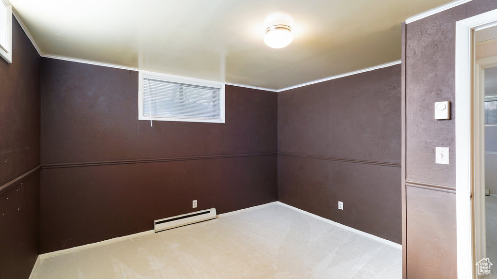 Empty room featuring baseboard heating and carpet flooring