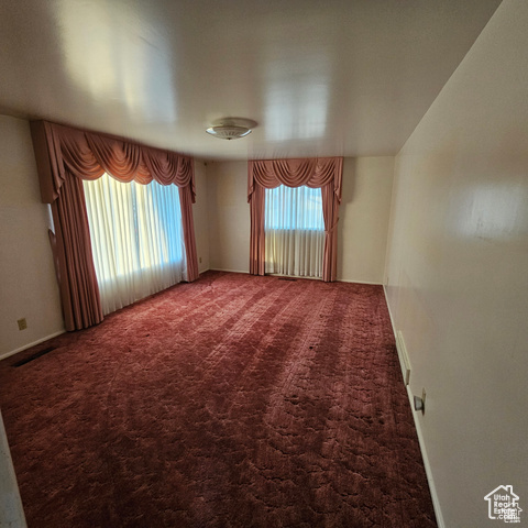 Empty room with carpet flooring and baseboards