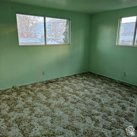 Carpeted empty room with baseboards