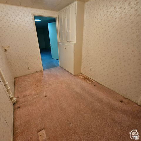 Carpeted empty room with wallpapered walls