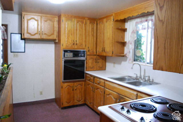 Kitchen featuring oven, a sink, range, and light countertops