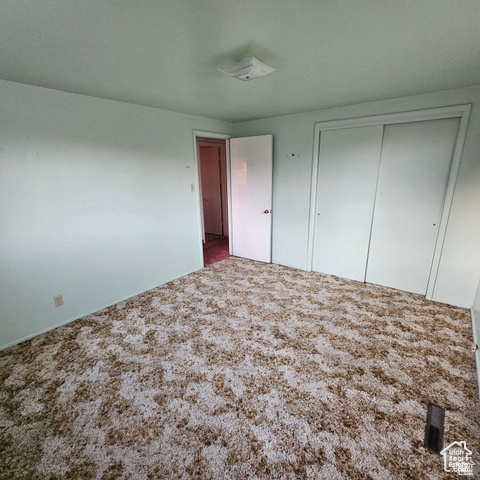 Unfurnished bedroom featuring carpet floors and a closet