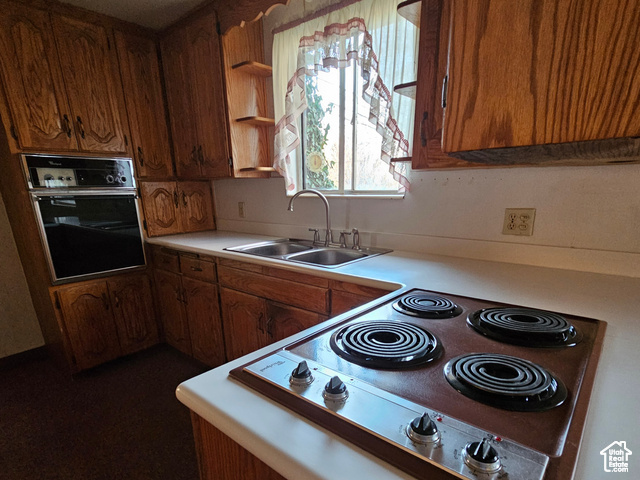 Kitchen with oven, range, a sink, and light countertops