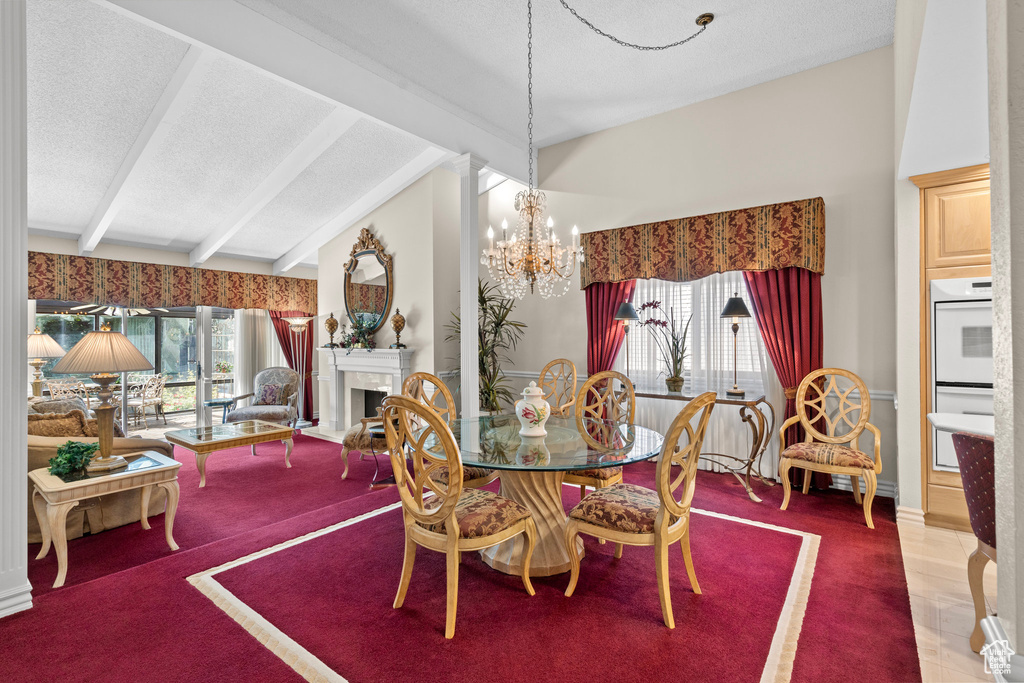 Carpeted dining space featuring a textured ceiling, a chandelier, a fireplace, and baseboards