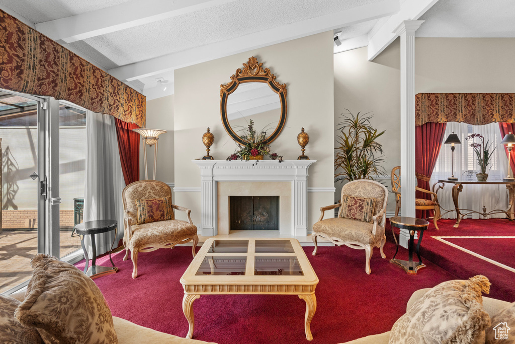 Living area featuring carpet flooring, a fireplace, and decorative columns