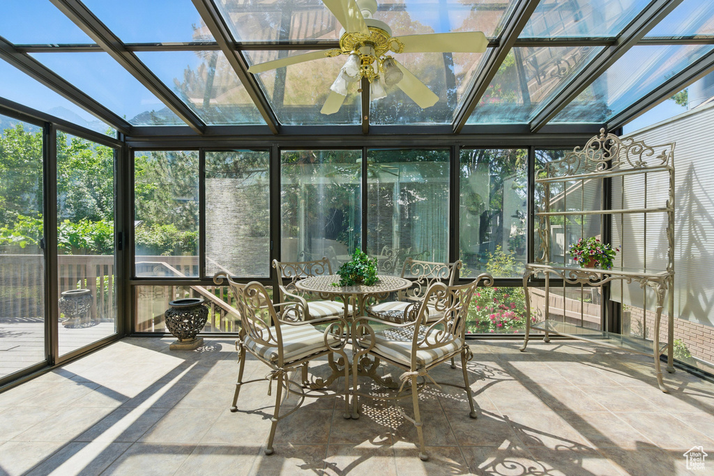 Sunroom / solarium featuring healthy amount of natural light, outdoor dining space, and a ceiling fan