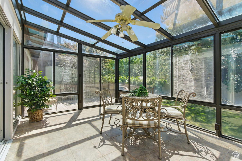 Sunroom / solarium with ceiling fan, healthy amount of natural light, and lofted ceiling