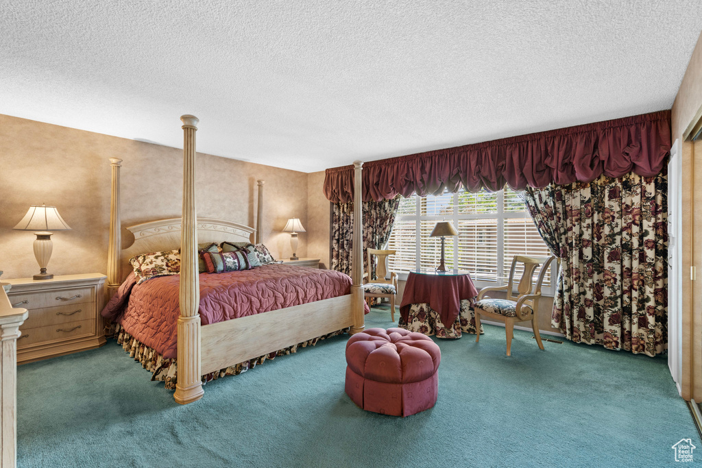 Bedroom featuring carpet and a textured ceiling