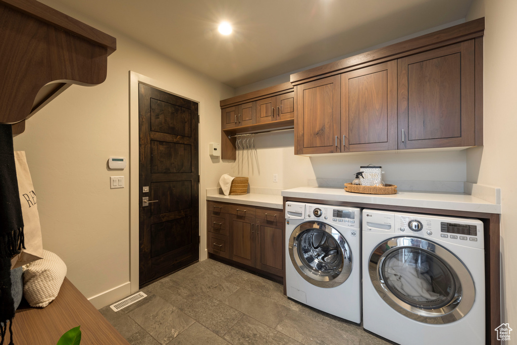 Laundry area with cabinet space, washer and dryer, and baseboards
