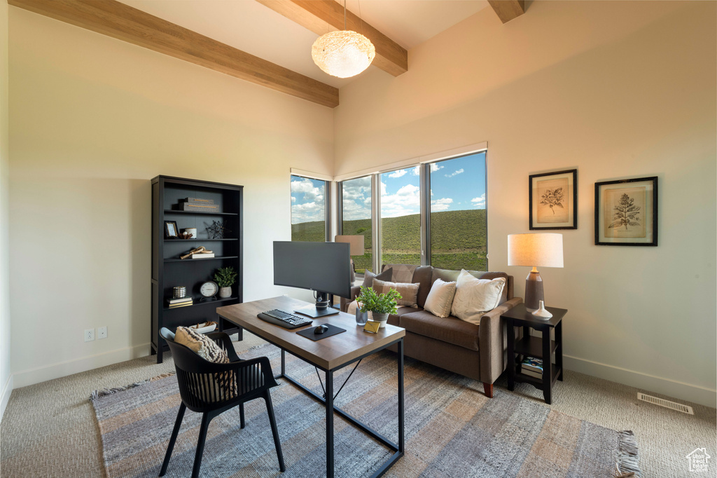 Home office with beam ceiling, carpet floors, and baseboards