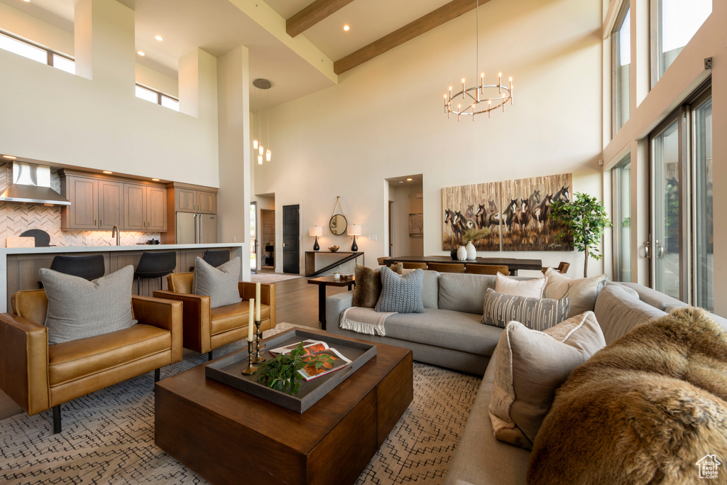 Living room with a high ceiling, a chandelier, and beamed ceiling