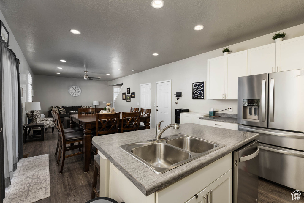 Kitchen featuring appliances with stainless steel finishes, a sink, dark wood-style flooring, recessed lighting, and open floor plan