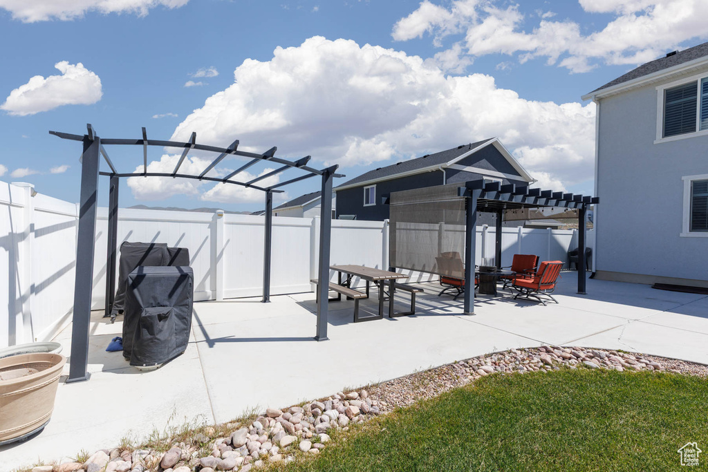 Fenced backyard with a pergola and a patio