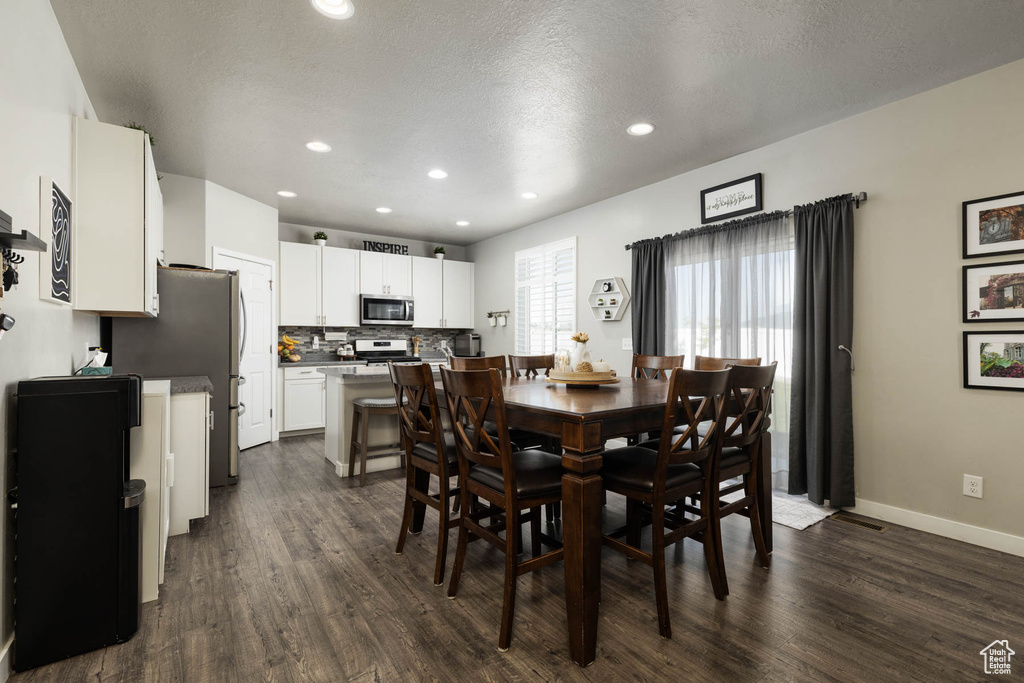 Dining room featuring dark wood-style flooring, recessed lighting, and baseboards