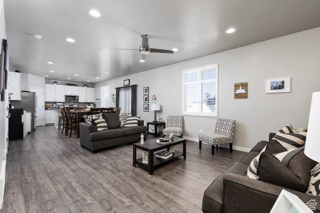 Living area with a ceiling fan, dark wood-style flooring, recessed lighting, and baseboards