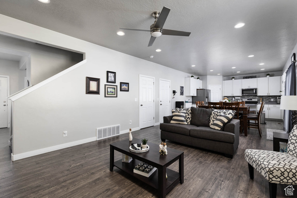 Living room featuring ceiling fan, dark wood-style floors, recessed lighting, and baseboards