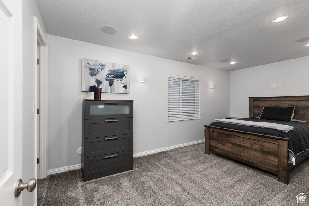 Bedroom with dark carpet, baseboards, and recessed lighting