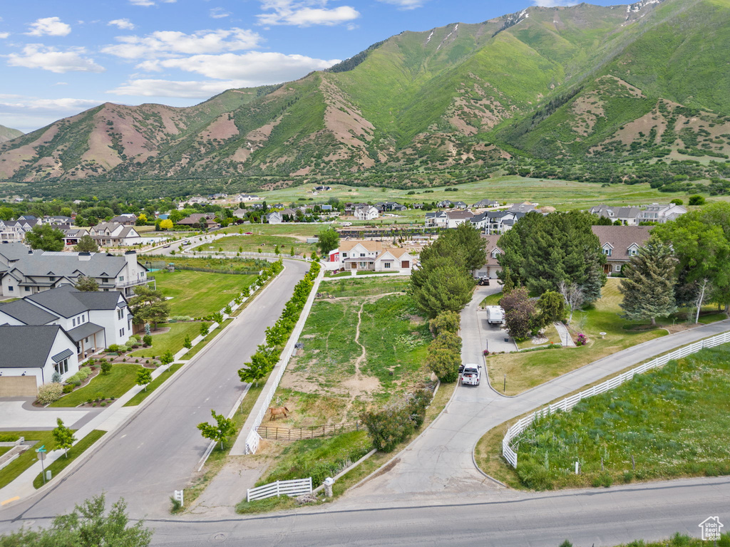 Aerial view of property and surrounding area featuring a mountain backdrop and nearby suburban area